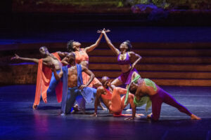 Dancers from @lula_washington_dance_theatre company posed in colorful costumes.