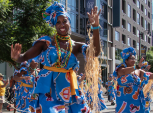 Black female @viverbrasildance dancer performing in the streets of downtown Los Angeles in a bright blue and ethnic outfit.