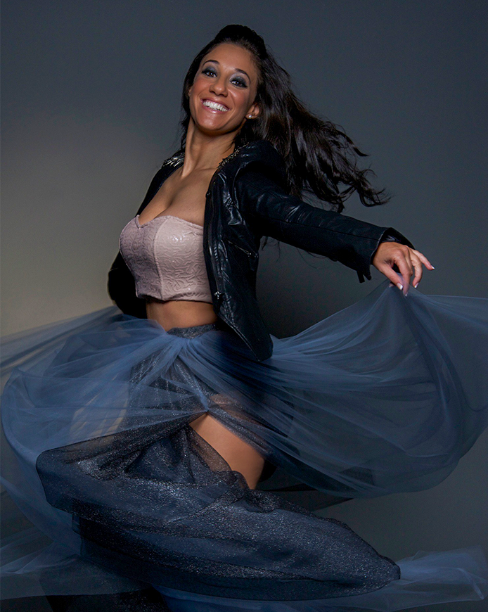 Dance Resource Center executive director @raelledorfan smiling while dancing in blue sheer skirt.