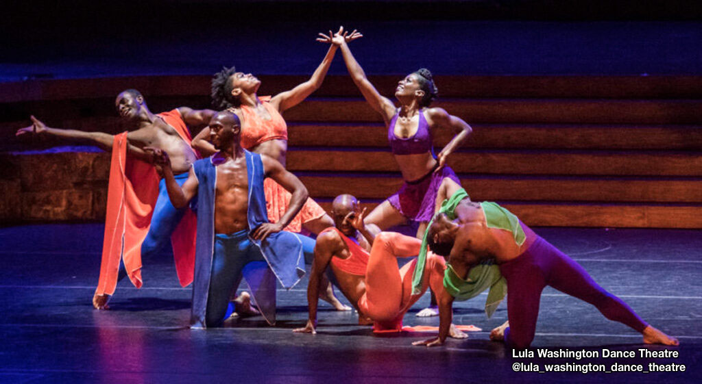 Dancers from @lula_washington_dance_theatre company posed in colorful costumes.