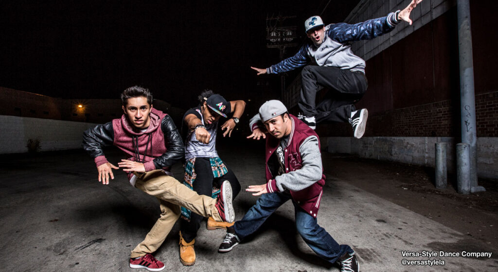 Four male hip-hop dancers from @versastylela posed on the street.